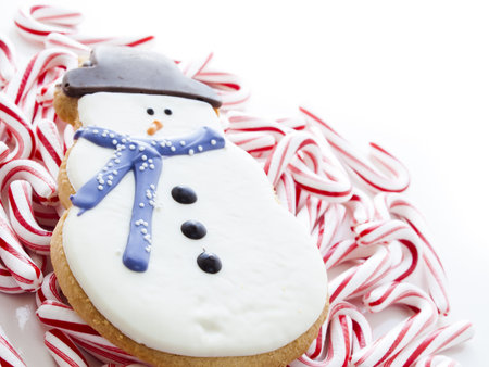 Gourmet snowman cookies with peppermint candy cane on white background.の写真素材