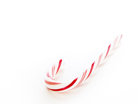 White and red peppermint candy cane on white background.の写真素材