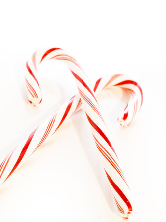 White and red peppermint candy cane on white background.