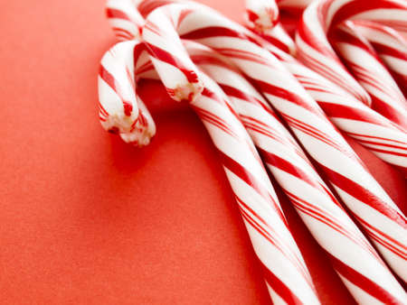 White and red peppermint candy canes on red background.の写真素材