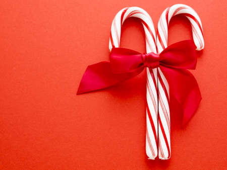 White and red peppermint candy canes on red background.の写真素材