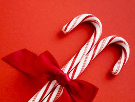 White and red peppermint candy canes on red background.の写真素材