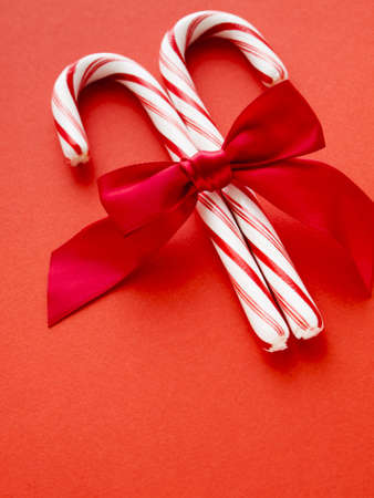 White and red peppermint candy canes on red background.の写真素材