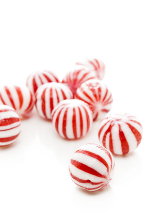 Gourmet white and red peppermint candies on white background.