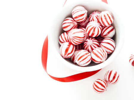 Gourmet white and red peppermint candies on white background.の写真素材