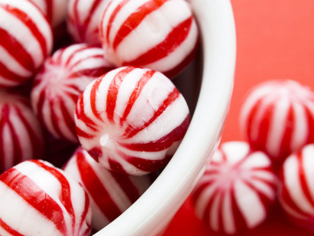 Gourmet white and red peppermint candies on red background.の写真素材