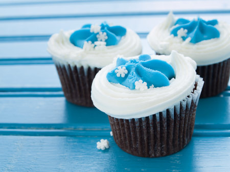 Gourmet chocolate cupcakes with white and blue icing.