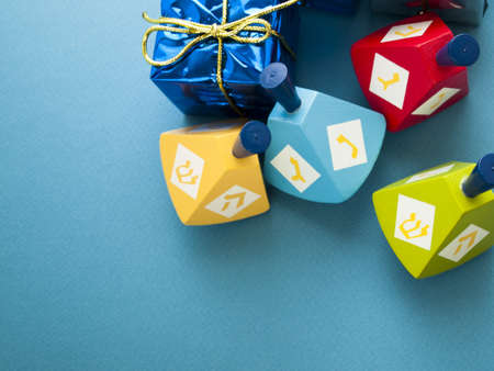 Colorful dreidels with presents on blue background.の写真素材