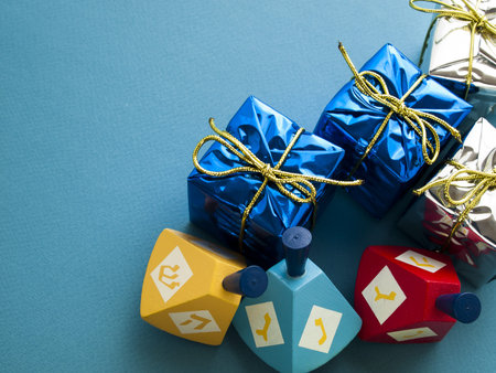 Colorful dreidels with presents on blue background.の写真素材