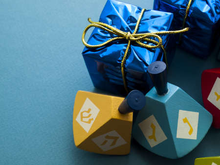 Colorful dreidels with presents on blue background.の写真素材
