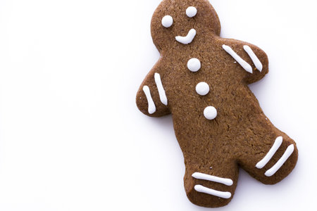 Homemade gingerbread cookies decorated with white icing on white background.
