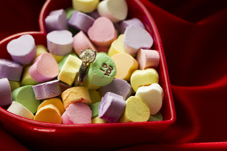 Canversation Heart candies in heart shaped container.