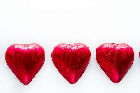 Heart shape chocolate candies on white background.の写真素材