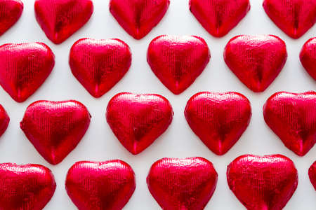 Heart shape chocolate candies on white background.の写真素材