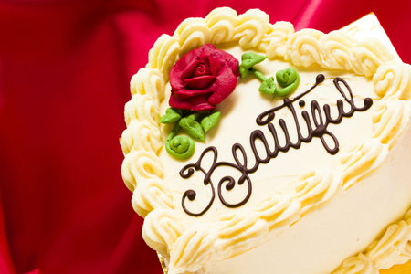 Heart shaped red velvet cake with white chocolate icing.