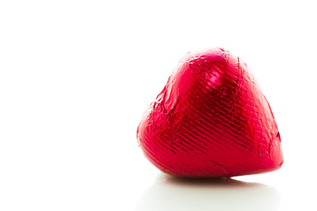 Heart shape chocolate candies wrapped in red foil for Valentine's Day.