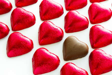 Heart shape chocolate candies wrapped in red foil for Valentine's Day.の写真素材
