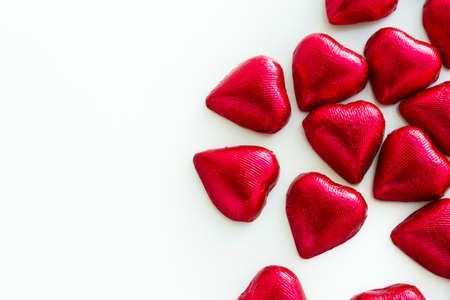 Heart shape chocolate candies wrapped in red foil for Valentine's Day.の写真素材