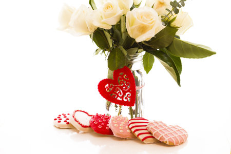 Gourmet cookies with bouquet of white roses.の写真素材