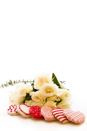 Gourmet cookies with bouquet of white roses.の写真素材