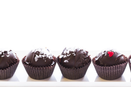 Gourmet salted caramel truffles on white background.