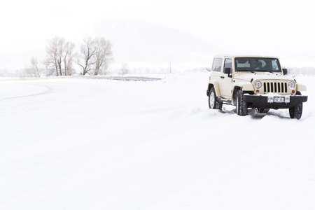 Small Jeep on the road covered with snow.のeditorial素材