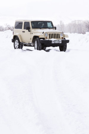 Small Jeep on the road covered with snow.