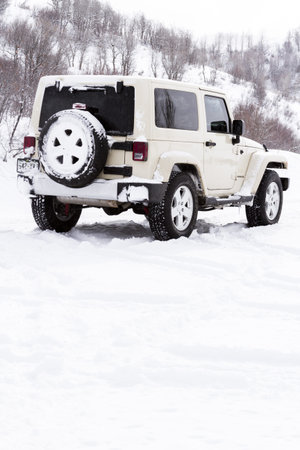 Small Jeep on the road covered with snow.のeditorial素材
