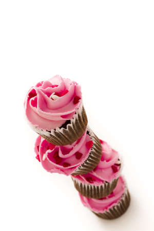 Stack of pink cupcakes on white background.の写真素材