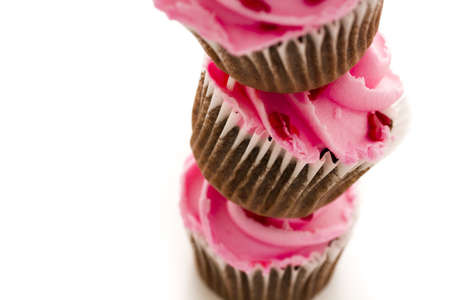 Stack of pink cupcakes on white background.の写真素材