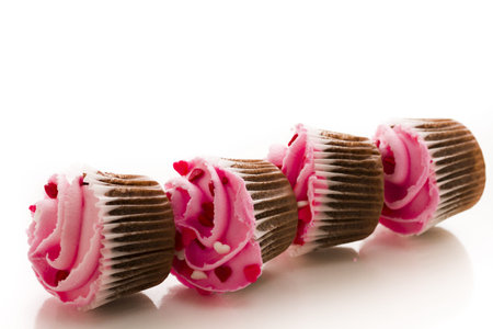 Stack of pink cupcakes on white background.の写真素材