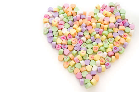 Pile of conversation heart candies in heart shape.の写真素材