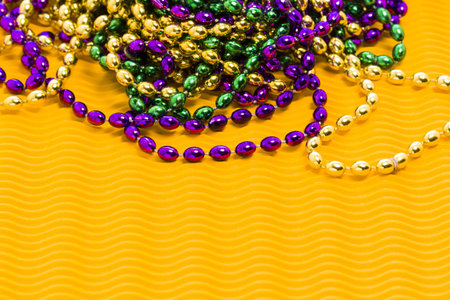 Mardi Gras beads yellow backgound.