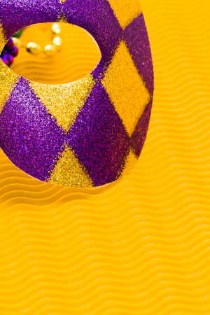 Mardi Gras beads and mask on yellow backgound.の写真素材