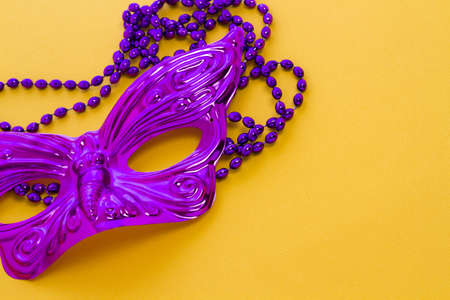 Mardi Gras beads and mask on yellow backgound.の写真素材