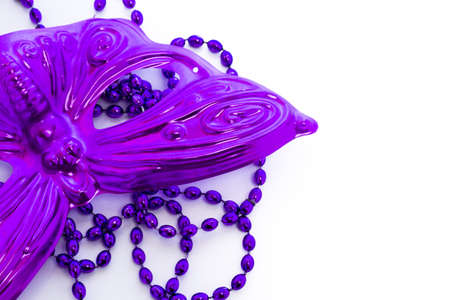 Mardi Gras purple beads and purple mask on white backgound.の写真素材