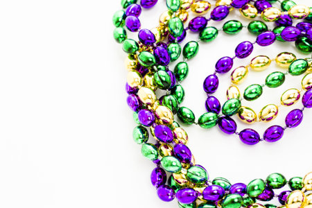 Multi color Mardi Gras beads on white background.