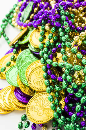 Multi color Mardi Gras beads and tokens on white background.の写真素材