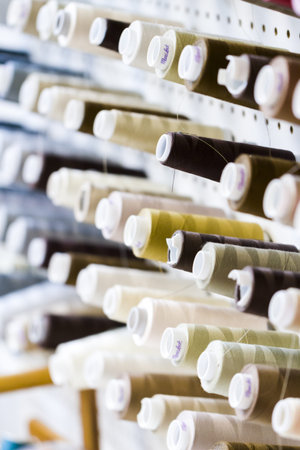 Colorful spools of thread on the wall in tailor shop.