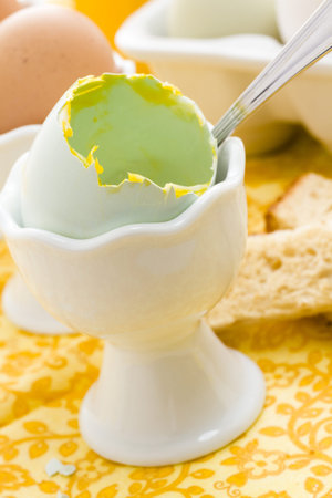 Soft boiled egg in egg cup and served with toast fingers.