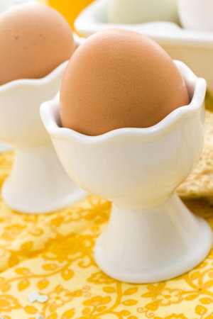Soft boiled egg in egg cup and served with toast fingers.