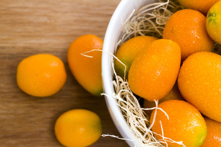 Organic kumquats in white bowl.