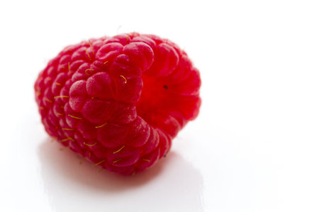 Heap of organic raspberries on white background.