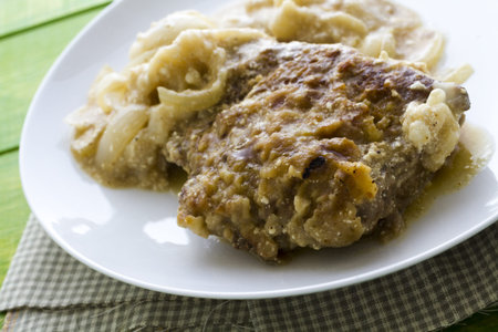 Fryed beef liver with onions on a white plate.の写真素材