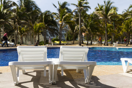 white plastic pool chairs at the swimming pool.のeditorial素材