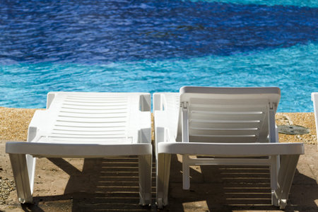 white plastic pool chairs at the swimming pool.