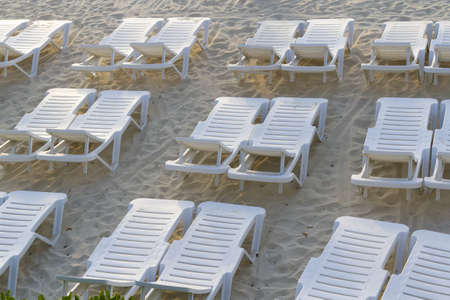 White pool chairs on the beach.の写真素材