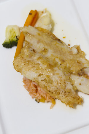 Grilled sea bass on white plate.