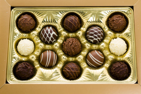 Box of assorted gourmet truffles on a white background.