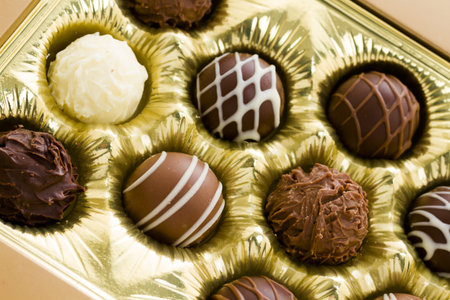 Box of assorted gourmet truffles on a white background.